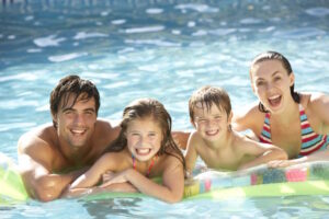 family swimming in pool